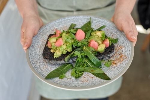 Waiter holding healthy meal on plate - Australian Stock Image