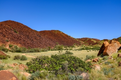 Walking track and red rock mountain off Karratha beach - Australian Stock Image