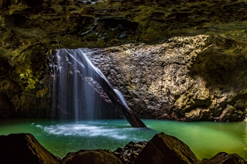 Water flowing through natural arch into underground cave - Australian Stock Image