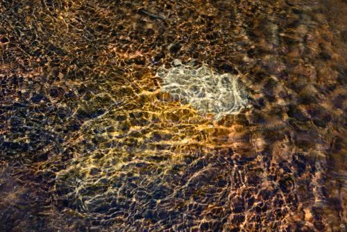 Water rippling over colourful sandstone - Australian Stock Image
