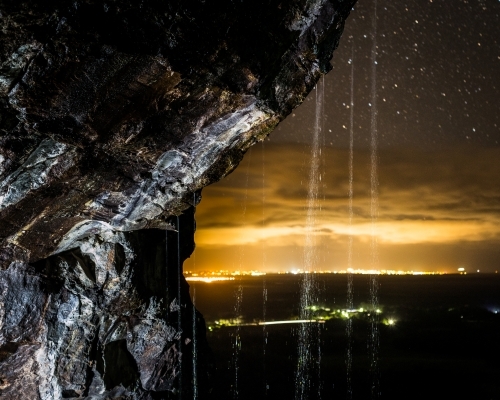 Waterfall against the nighttime lights of the Sunshine Coast - Australian Stock Image