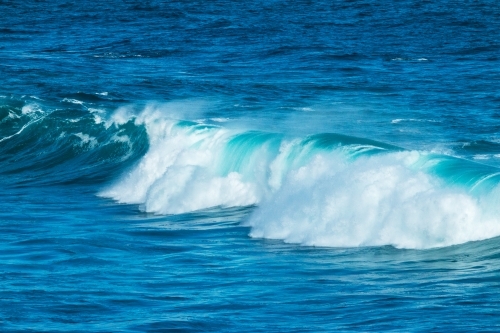 wave tumbling on blue water - Australian Stock Image