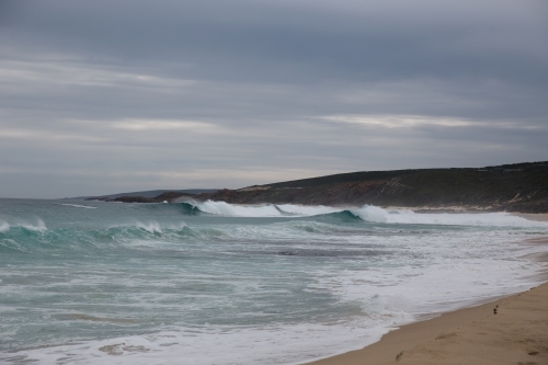 Waves breaking on an overcast day at the beach - Australian Stock Image