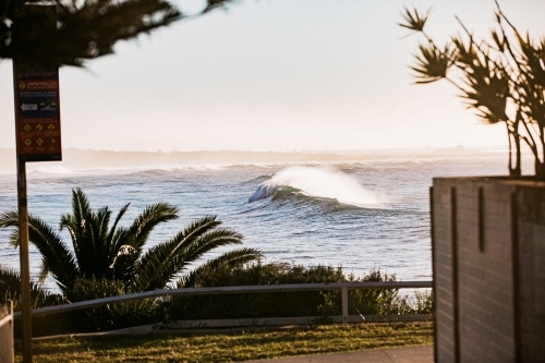 Waves crashing coastline at sunrise with sea spray - Australian Stock Image