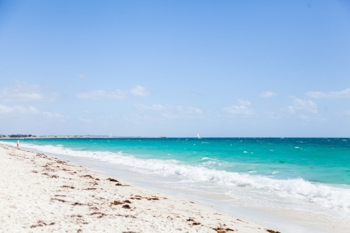 Waves wash up on white beach sand - Australian Stock Image