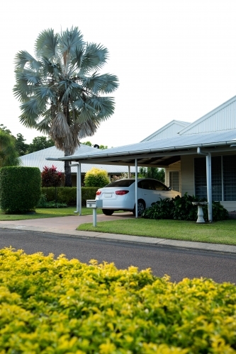 Weatherboard home in a picturesque street with hedge in the middle of the road - Australian Stock Image