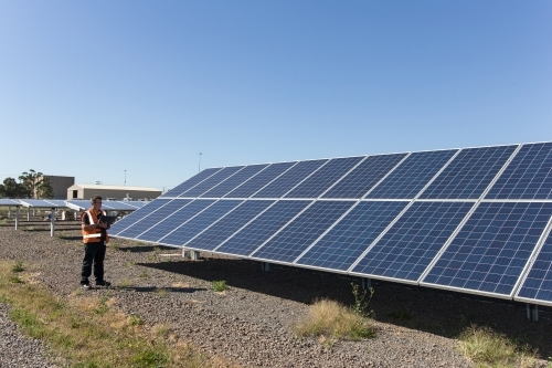 Wide angle of an employee taking notes at a Solar Panel Plant - Australian Stock Image