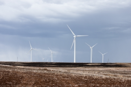 Wind farm in paddock with incoming storm - Australian Stock Image