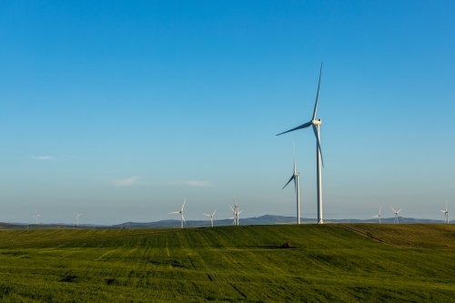 wind towers in late afternoon with farmland in foreground - Australian Stock Image