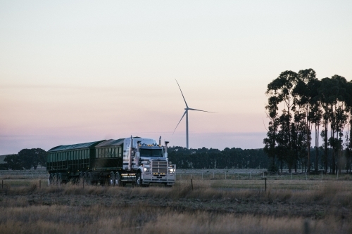 Wind turbine in the countryside on dusk with Semi Trailer transport foreground details - Australian Stock Image