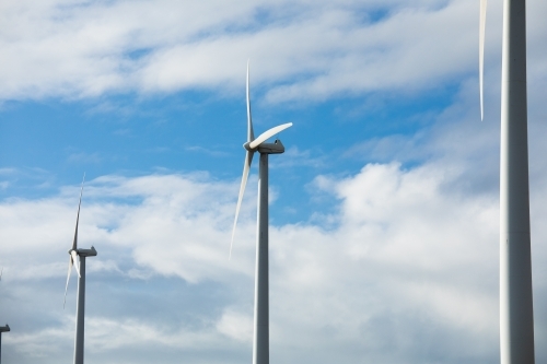 Wind turbines in a row against a cloudy sky - Australian Stock Image