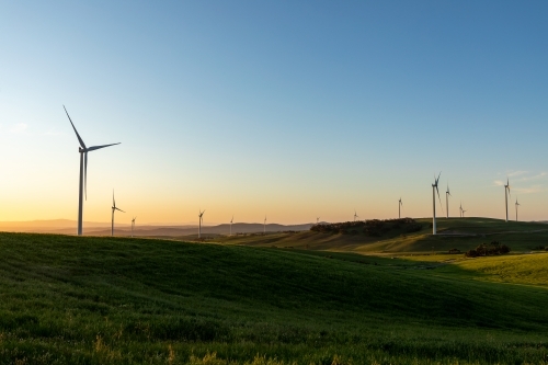 wind turbines in rolling farmland in late afternoon light - Australian Stock Image