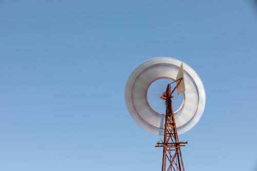 Windmill against bright blue summer sky - Australian Stock Image