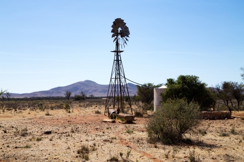 windmill and tank in dry landscape - Australian Stock Image