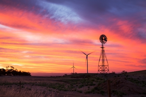 Windmill and wind turbines silhouetted against sunset - Australian Stock Image