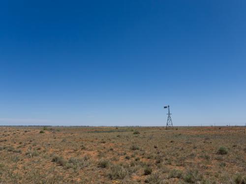 Windmill in arid landscape - Australian Stock Image