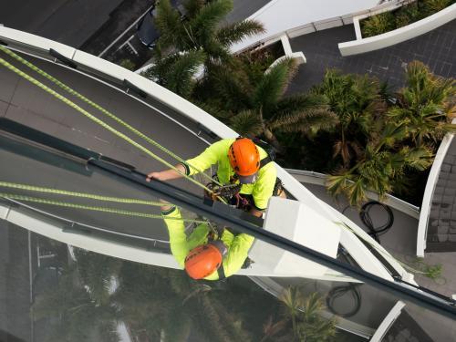 Window cleaner abseiling down a tall building on the Gold Coast