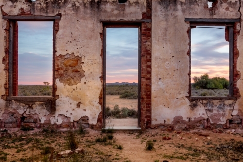 Window views from abandoned rustic ruin of a pretty desert sunrise - Australian Stock Image