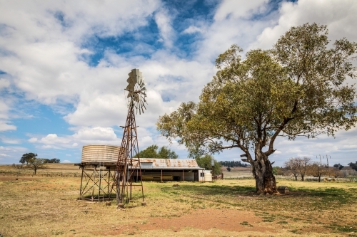 Windpump (windmill), water tank and haystack barn on a dry farmland property - Australian Stock Image