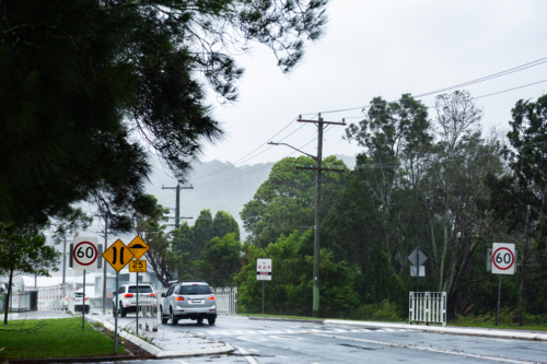 Windy stormy day with traffic on road in Newcastle driving on wet street - Australian Stock Image