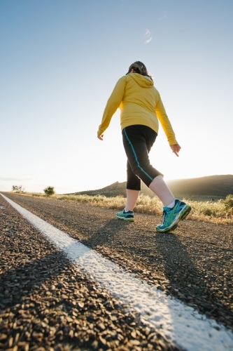 Woman doing exercise on a remote country road - Australian Stock Image