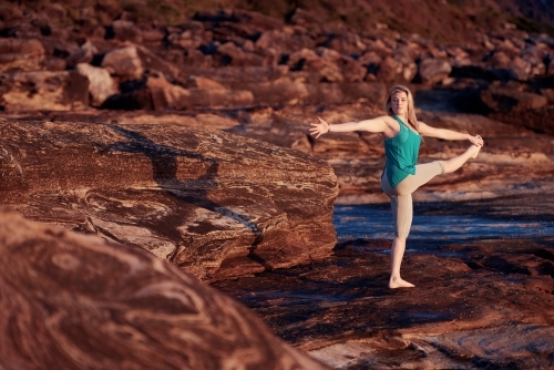 Woman doing yoga by the ocean - Australian Stock Image