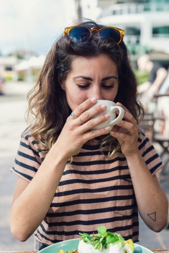 woman drinking tea in cafe - Australian Stock Image