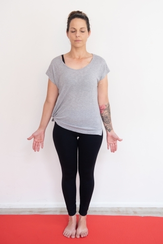 woman full length mountain pose eyes closed yoga on mat in studio - Australian Stock Image