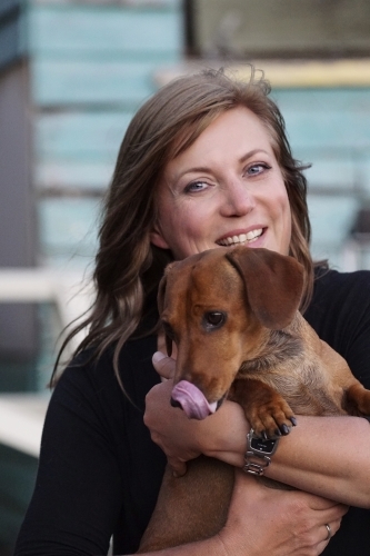 Woman holding dog close up - Australian Stock Image