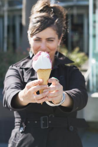 Woman holding out an ice cream cone - Australian Stock Image