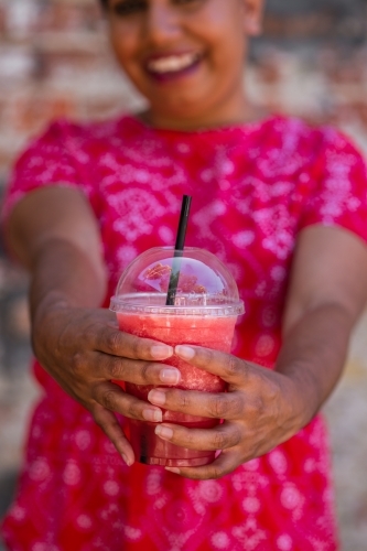 woman holding pink smoothie drink - Australian Stock Image