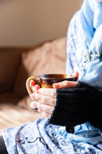 Woman holding warm mug of chai tea in winter - Australian Stock Image