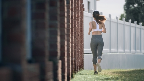 Woman in active wear running for morning exercise - Australian Stock Image