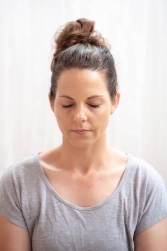 woman in moment of peace eye closed in meditation pose - Australian Stock Image