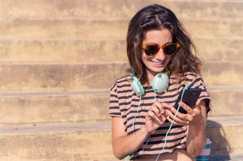 woman listening to music outdoors - Australian Stock Image