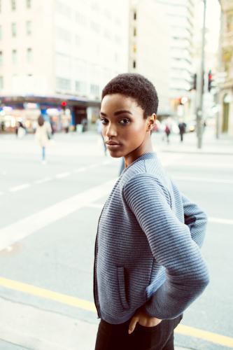 Woman looking over her shoulder with hands in pockets - Australian Stock Image