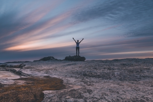 Woman on rock with arm outstretched Lincoln's Rock Kings Tableland. - Australian Stock Image