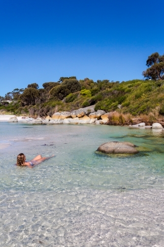 Woman sea bathing in crystal clear waters of Tasmania - Australian Stock Image