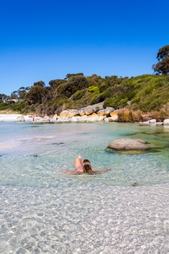 Woman sea bathing in crystal clear waters of Tasmania - Australian Stock Image