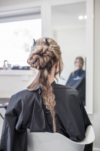 Woman sitting in hairdressing salon getting hair done - Australian Stock Image