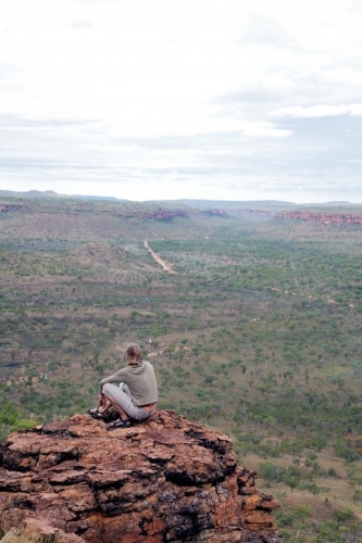 Woman sitting on clifftop in outback Australia - Australian Stock Image