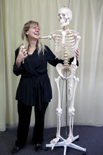Woman standing and laughing with skeleton