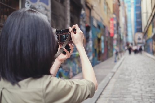 Woman taking picture of graffiti wall - Australian Stock Image