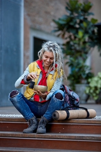 Woman using Tibetan singing bowl - Australian Stock Image