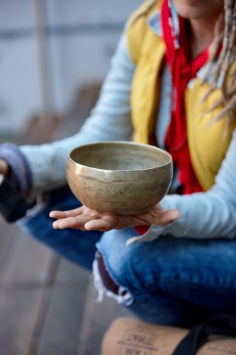 Woman using Tibetan singing bowl - Australian Stock Image