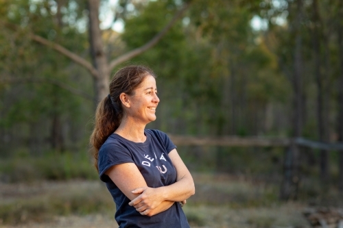 woman with crossed arms standing outdoors - Australian Stock Image