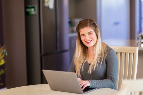 Woman working from home on laptop computer - Australian Stock Image