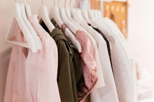Women cloths on hangers in a row. - Australian Stock Image