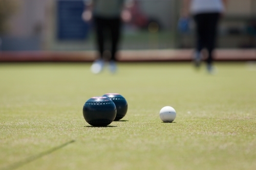 Women walking on green towards bowls and jack - Australian Stock Image