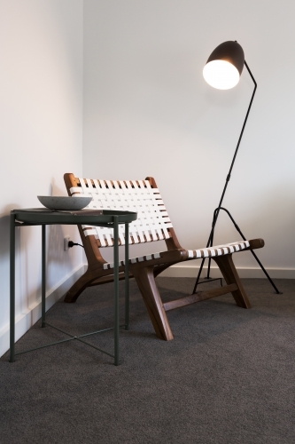 Wood and woven occasional chair with floor lamp and side table - Australian Stock Image